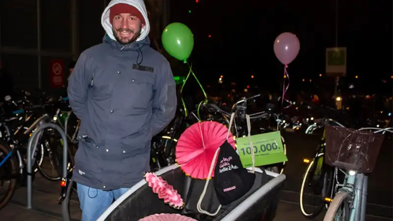 Michael, der 100.000ste Fahrradfan steht stolz neben seinem geschmückten Lastenrad