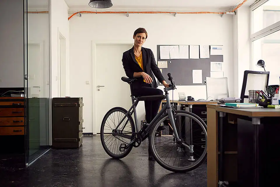 Frau mit Fahrrad im Büro